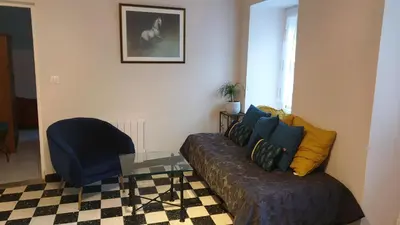 a living room with a couch and a blue chair at LE CLOS DES COLVERTS in Campagne-sur-Aude
