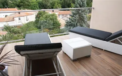 a balcony with a couch and a table and a fireplace at Les Suites du Saint Nazaire, vue panoramique sur la Cité Médiévale - Les Balcons de la Cité in Carcassonne