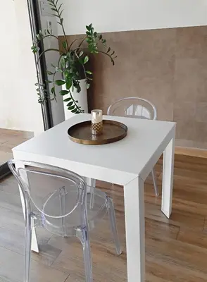 a white table with two chairs and a cup on it at Les Suites du Saint Nazaire, vue panoramique sur la Cité Médiévale - Les Balcons de la Cité in Carcassonne