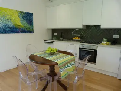 a kitchen with a table and chairs and a kitchen with white cabinets at Maison Pigeonnier in Alet-les-Bains