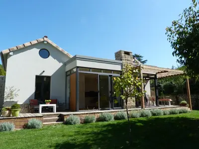 a house with glass doors and a lawn at Maison Pigeonnier in Alet-les-Bains
