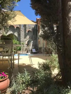 a patio with a table and chairs and an umbrella at Chateau Marcel in Cesseras