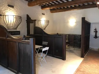 a church with wooden stalls and a cross on the wall at Chateau Marcel in Cesseras