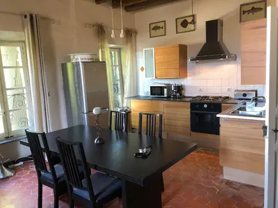 a kitchen with a black table and chairs in it at Chateau Marcel in Cesseras