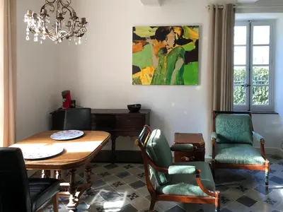 a living room with a table and chairs and a chandelier at Chateau Marcel in Cesseras