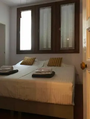 a bedroom with a large bed with two windows at Chateau Marcel in Cesseras