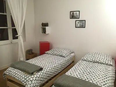 two twin beds in a room with a window at Aux 4 FONTAINES in Narbonne
