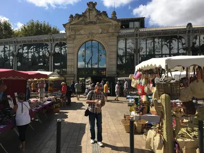 a man walking through a market in front of a building at Aux 4 FONTAINES in Narbonne