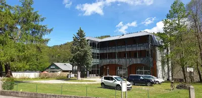a building with two cars parked in front of it at Résidence les Mélèzes de Prades Ariège in Prades