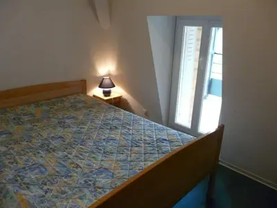 a bedroom with a bed and a window and a lamp at Résidence les Mélèzes de Prades Ariège in Prades