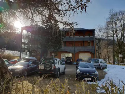 a parking lot with cars parked in front of a building at Résidence les Mélèzes de Prades Ariège in Prades