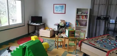 a room with a play room with a table and chairs at Résidence les Mélèzes de Prades Ariège in Prades
