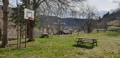 a basketball hoop and a bench in a field at Résidence les Mélèzes de Prades Ariège in Prades
