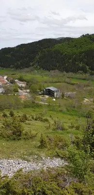 a field of grass with a building in the distance at Résidence les Mélèzes de Prades Ariège in Prades