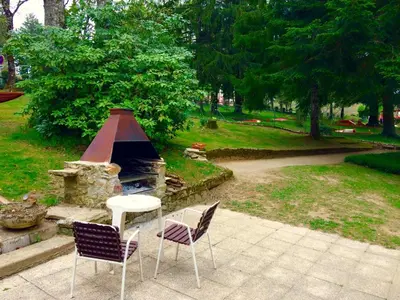 two chairs and a table next to a stone oven at Studio duplex 1 Lac des Montagnès in Mazamet