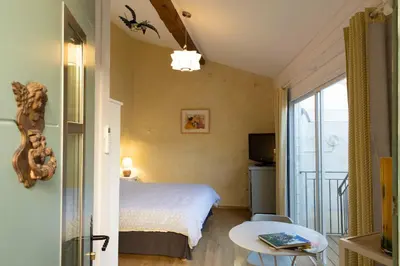 a hotel room with a bed and a balcony at Chambre indépendante à Carcassonne in Carcassonne