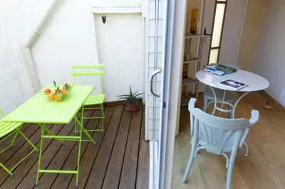 a small balcony with a table and a table and chairs at Chambre indépendante à Carcassonne in Carcassonne