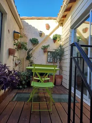 a green chair sitting on a wooden deck at Chambre indépendante à Carcassonne in Carcassonne