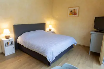 a bedroom with a bed and two night stands and a television at Chambre indépendante à Carcassonne in Carcassonne