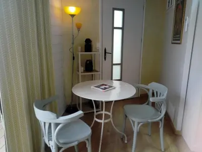 a table with four chairs and a book on it at Chambre indépendante à Carcassonne in Carcassonne