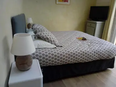 a bedroom with a bed with a lamp on a nightstand at Chambre indépendante à Carcassonne in Carcassonne