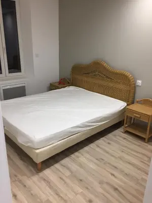 a bed in a room with a white mattress at La cathare appartement in Lézignan-Corbières