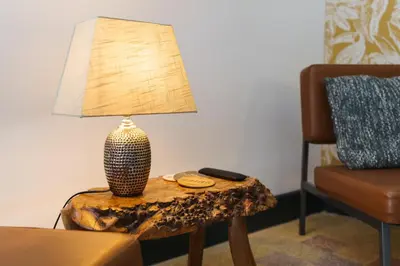 a lamp sitting on top of a table next to a chair at Logement Onze Chambres & Gîtes in Raissac-dʼAude