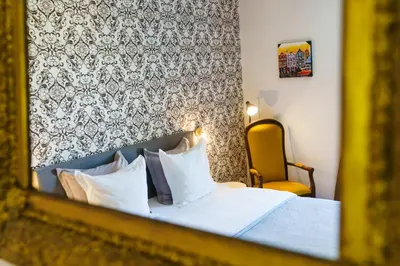 a reflection of a bedroom with a bed and a chair at Logement Onze Chambres & Gîtes in Raissac-dʼAude