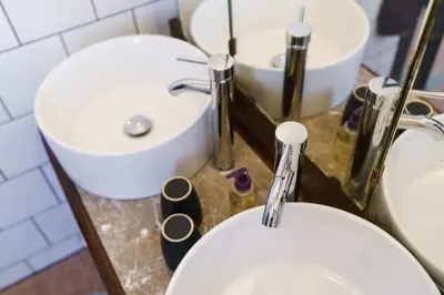 a bathroom with a white toilet and a sink at Logement Onze Chambres & Gîtes in Raissac-dʼAude
