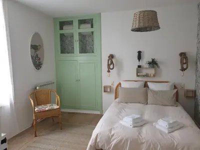 a bedroom with a bed with a green door at Chambres d'Hôtes et Gîtes- L'Abri sous Roche in Tautavel