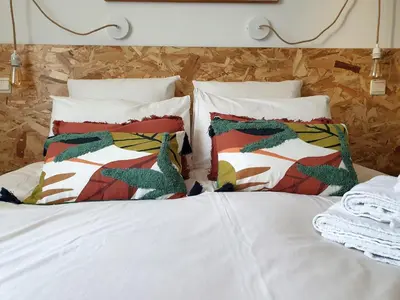a bed with white sheets and pillows on it at Chambres d'Hôtes et Gîtes- L'Abri sous Roche in Tautavel
