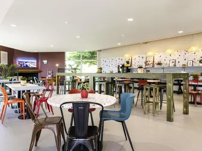 a restaurant with tables and chairs and a bar at Greet Hôtel Castres Saix in Saix