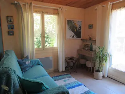 a living room with a blue couch and a window at KiOui in Rennes-les-Bains
