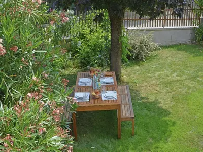 a wooden table in a garden with plates and dishes at Spacious Villa Retreat in Carcassonne in Carcassonne