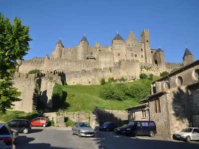 a castle on top of a hill with cars parked at Spacious Villa Retreat in Carcassonne in Carcassonne