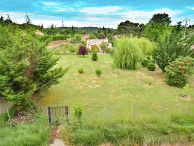 a garden with trees and bushes in a field at Holiday Home Talairan with Pool and BBQ in Talairan