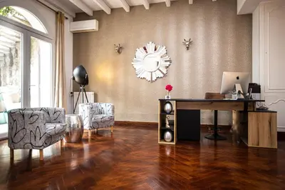 a living room with a desk and chairs and a clock at 45BB in Carcassonne