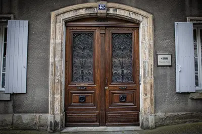 a large wooden door on a building with a sign on it at 45BB in Carcassonne