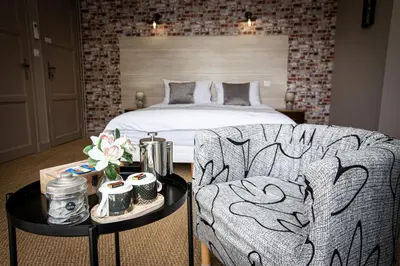 a bedroom with a bed and a chair and a table at 45BB in Carcassonne
