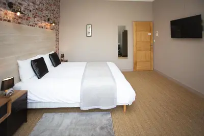 a bedroom with a large white bed and a flat screen tv at 45BB in Carcassonne