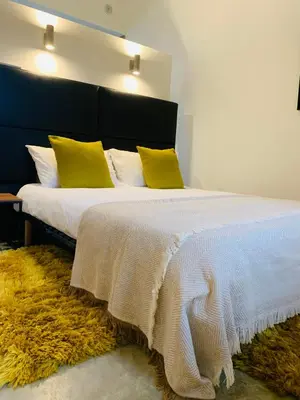 a bedroom with a large bed with yellow pillows at 45BB Apartment in Carcassonne