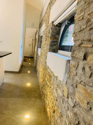 a room with a stone wall and a hallway at 45BB Apartment in Carcassonne