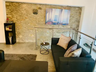 a living room with a couch and a stone wall at 45BB Apartment in Carcassonne