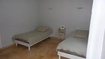 a bedroom with two beds and a tiled floor at spacieux logement face à la Cité Médievale in Carcassonne