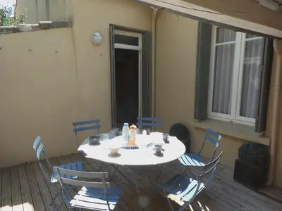 a white table and chairs on a patio at spacieux logement face à la Cité Médievale in Carcassonne