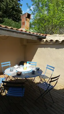 a table and chairs sitting on a porch with a candle at spacieux logement face à la Cité Médievale in Carcassonne