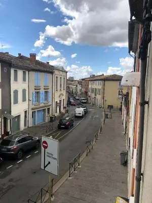 a city street with cars parked on the street at spacieux logement face à la Cité Médievale in Carcassonne