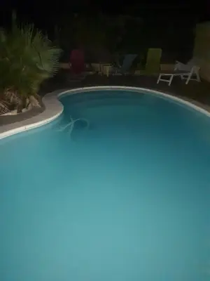 a swimming pool in a yard at night at Méditerranée in Sigean