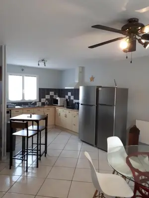 a kitchen with a refrigerator and a table and chairs at Méditerranée in Sigean