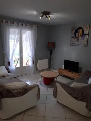 a living room with two beds and a table at Méditerranée in Sigean